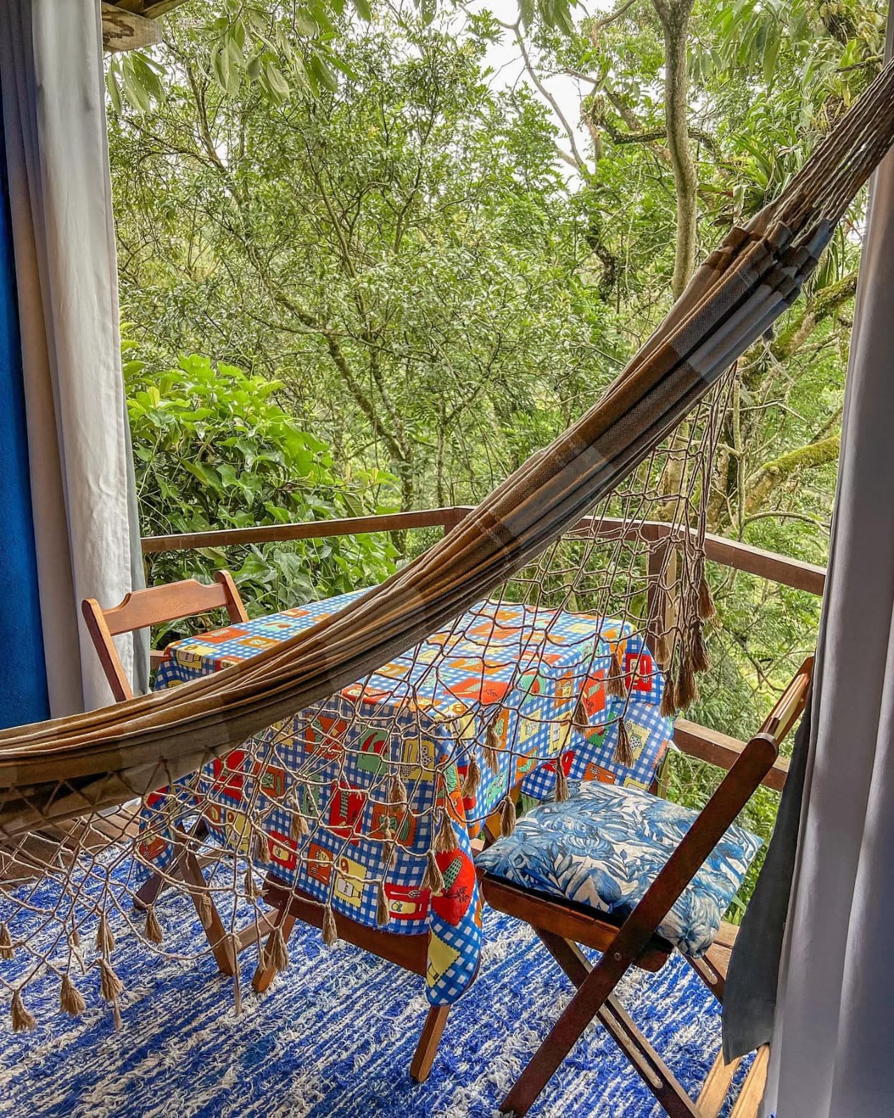 Varanda do Chalé Azul com rede e vista para a mata